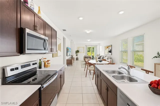 a large kitchen with stainless steel appliances granite countertop a sink stove and refrigerator