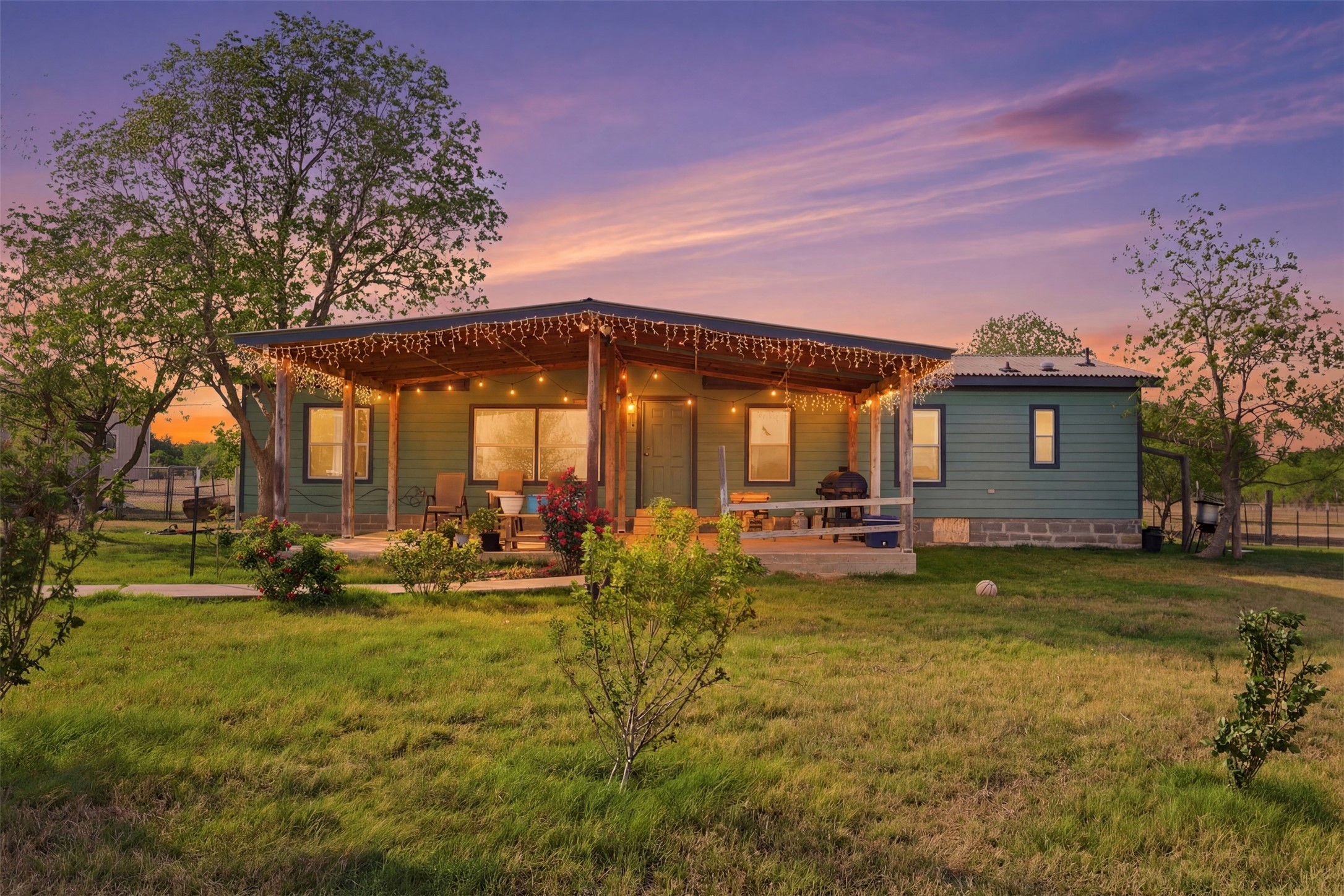 Back of property at dusk featuring a metal roof and a patio area