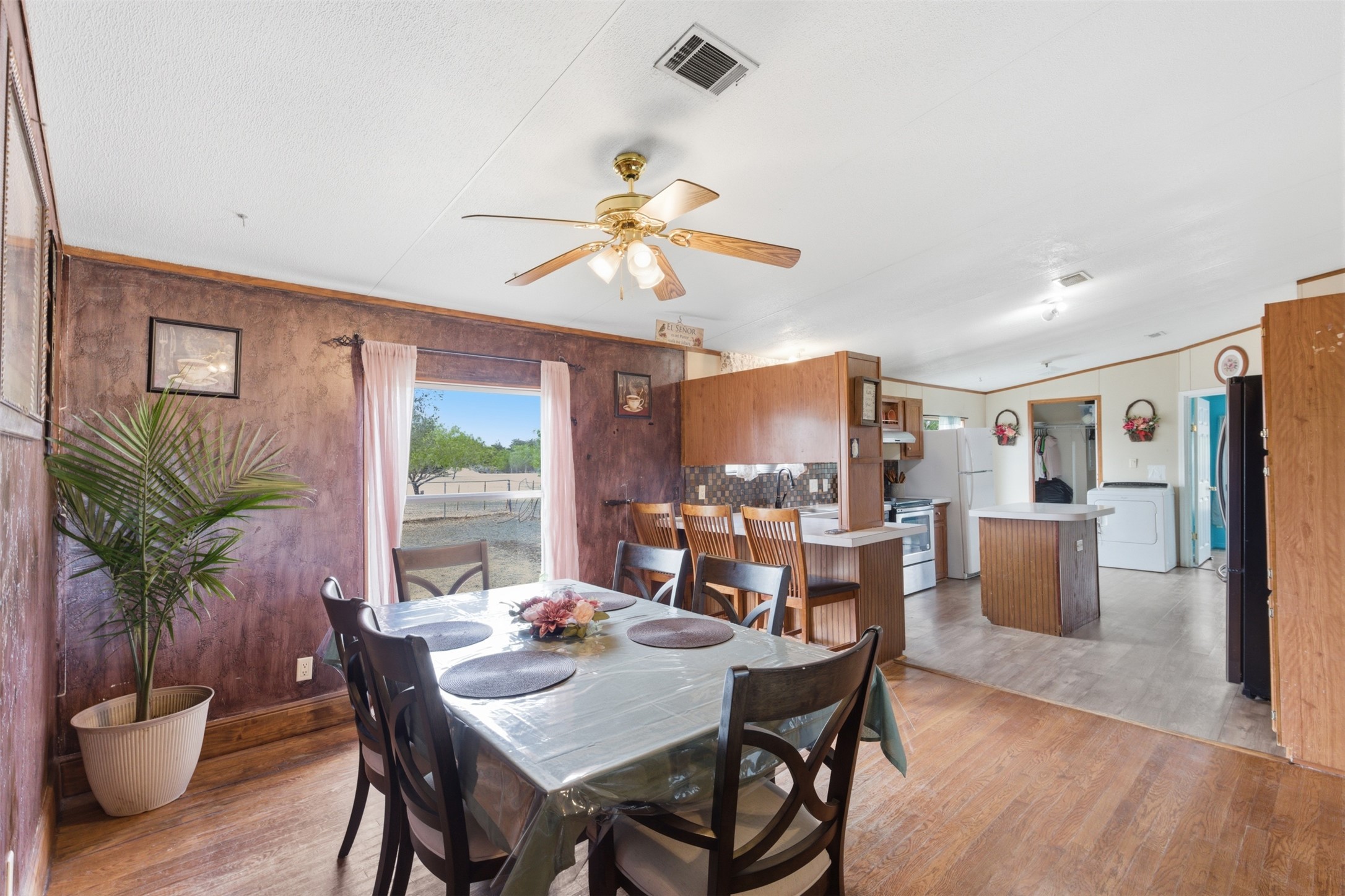 1150 Walter Hoffman Road Cedar Creek, TX 78612 - Photo 13 of 25 Dining area with washer / dryer, light wood-style floors, a ceiling fan, and ornamental molding