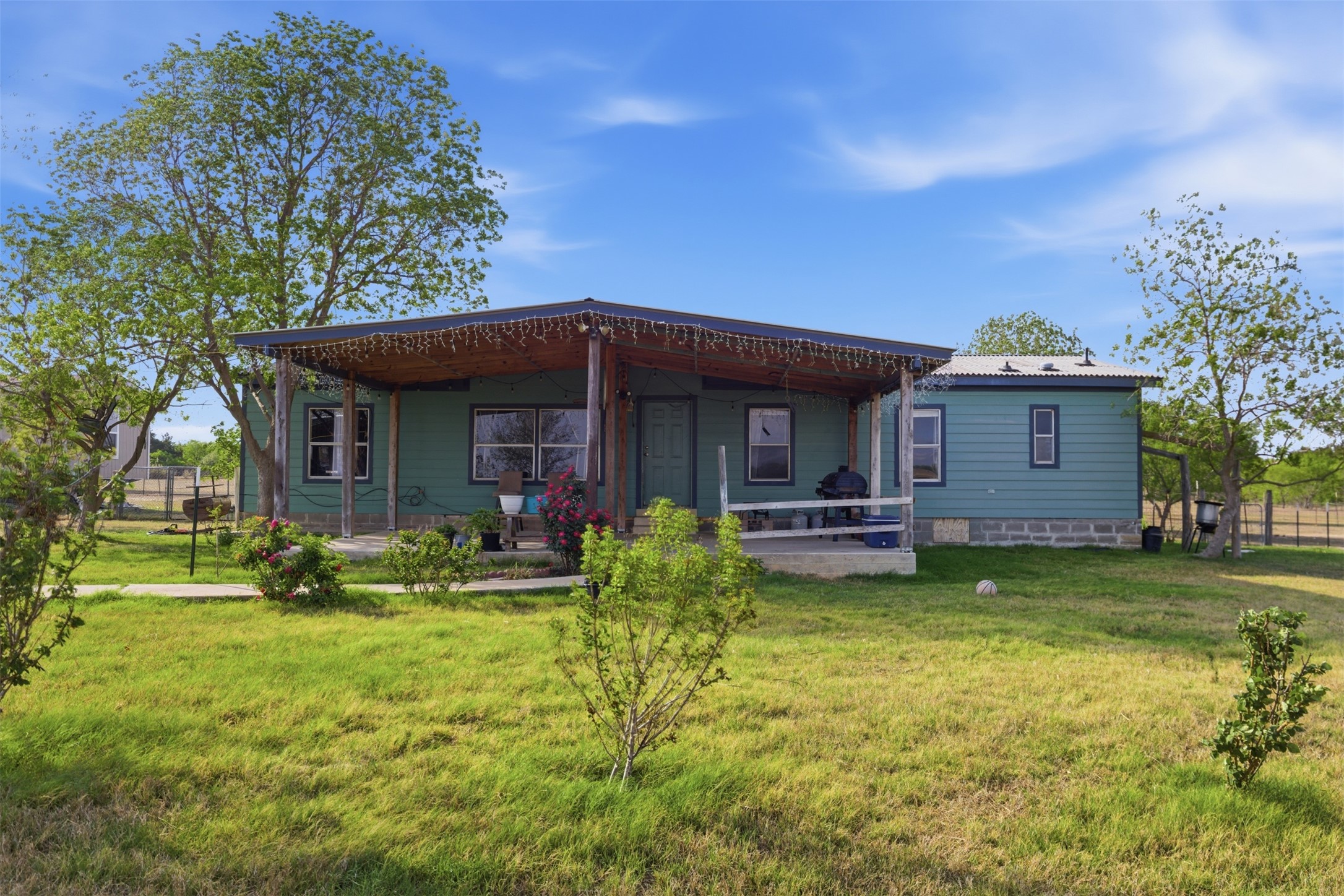 1150 Walter Hoffman Road Cedar Creek, TX 78612 - Photo 2 of 25 Back of house with a yard, a patio area, and a metal roof