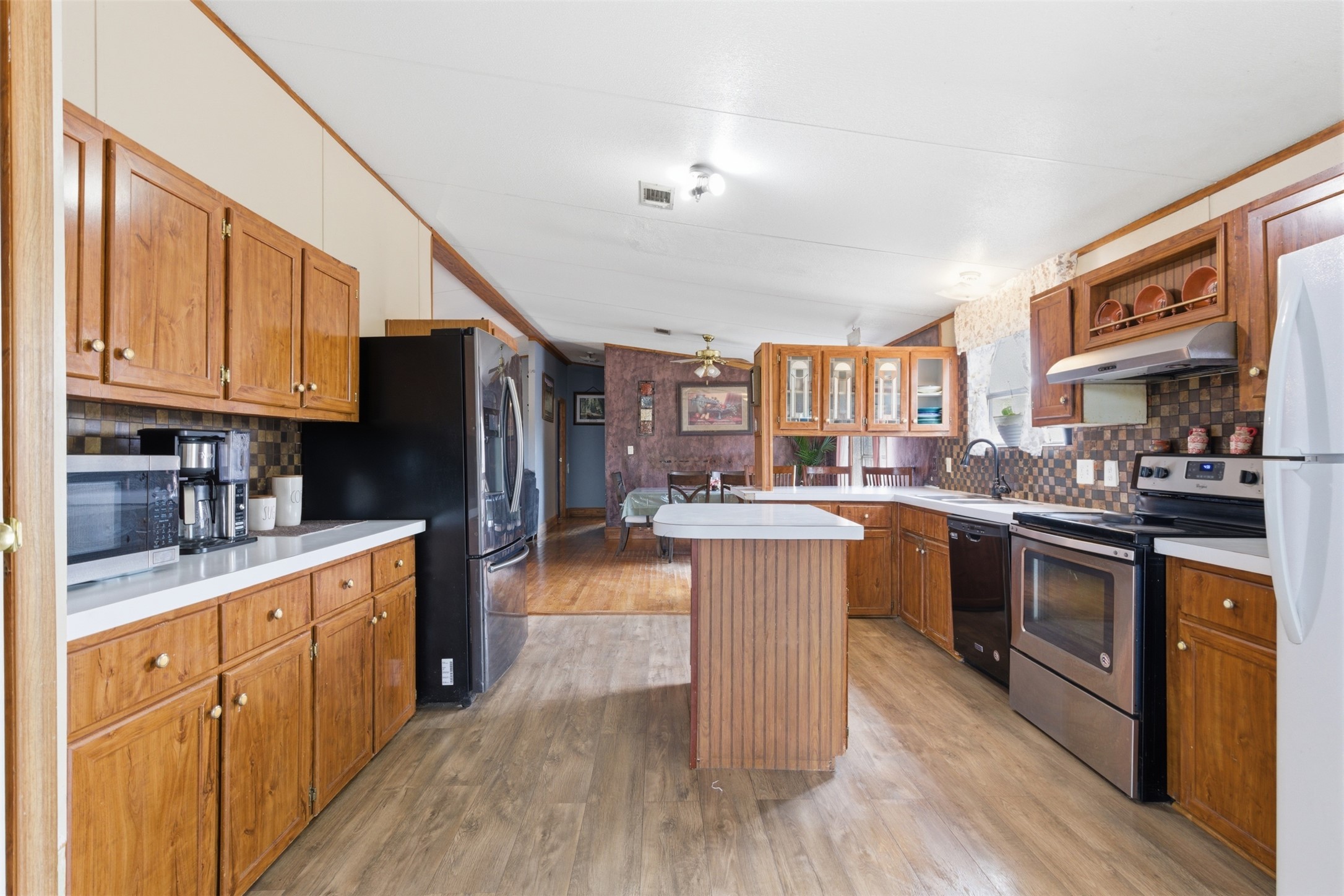 1150 Walter Hoffman Road Cedar Creek, TX 78612 - Photo 9 of 25 Kitchen with stainless steel appliances, wood finish cabinetry, backsplash, light countertops, and ornamental molding