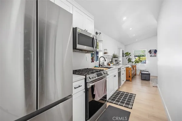 a kitchen with stainless steel appliances a stove a sink and a microwave