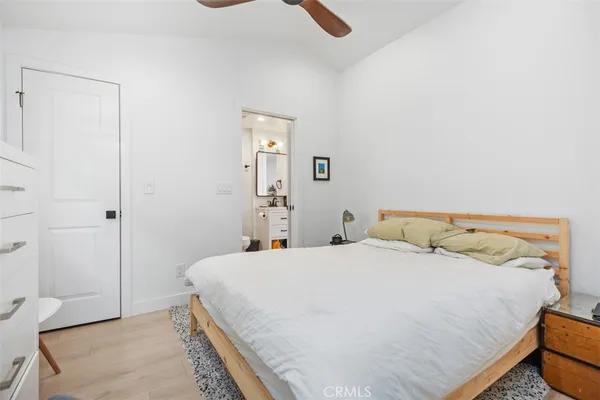 a bedroom with a bed and painting on the wall