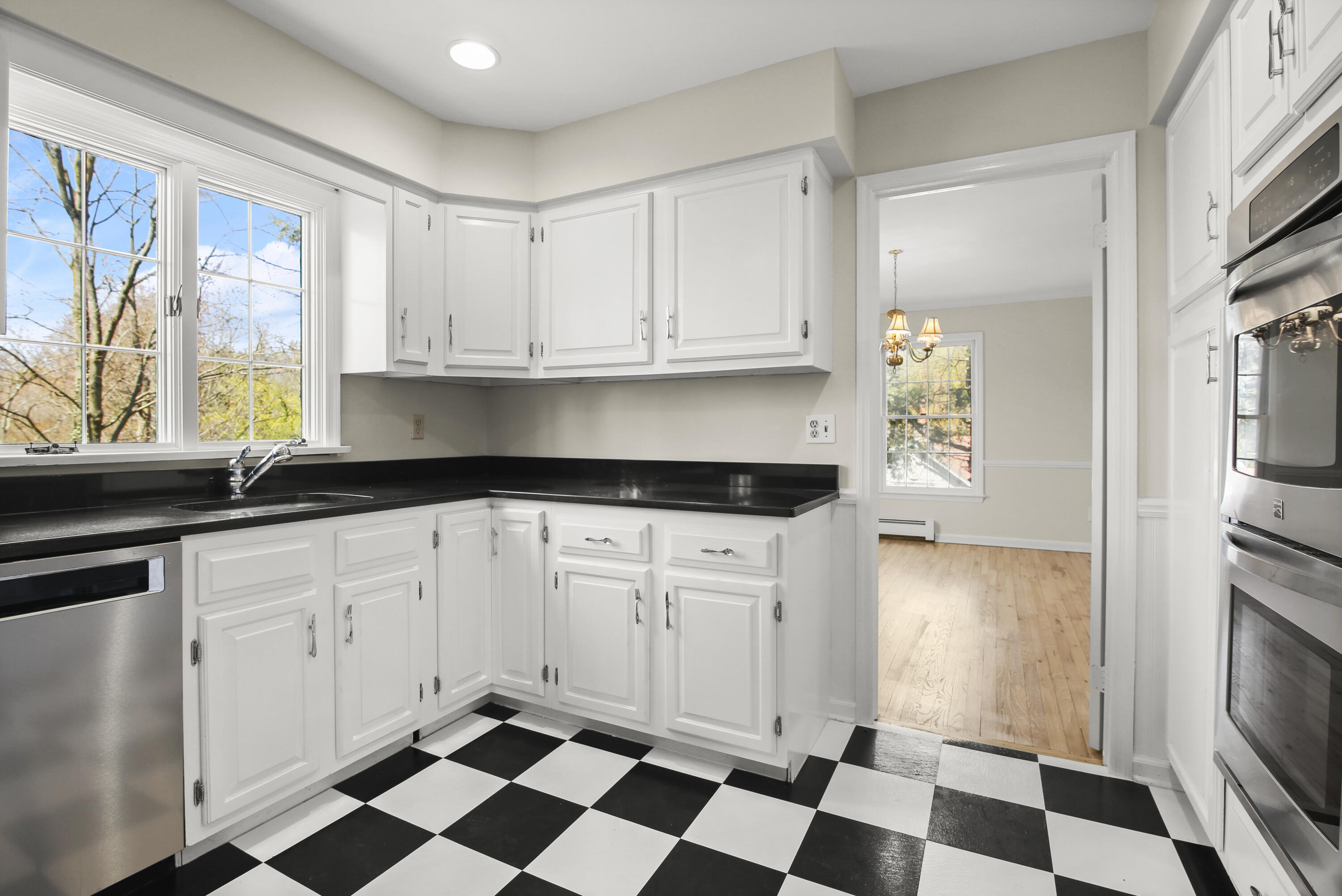 5 Barringer Road Darien, CT 06820 - Photo 9 of 39 a kitchen with a checkered floor and white cabinets with a stove top oven