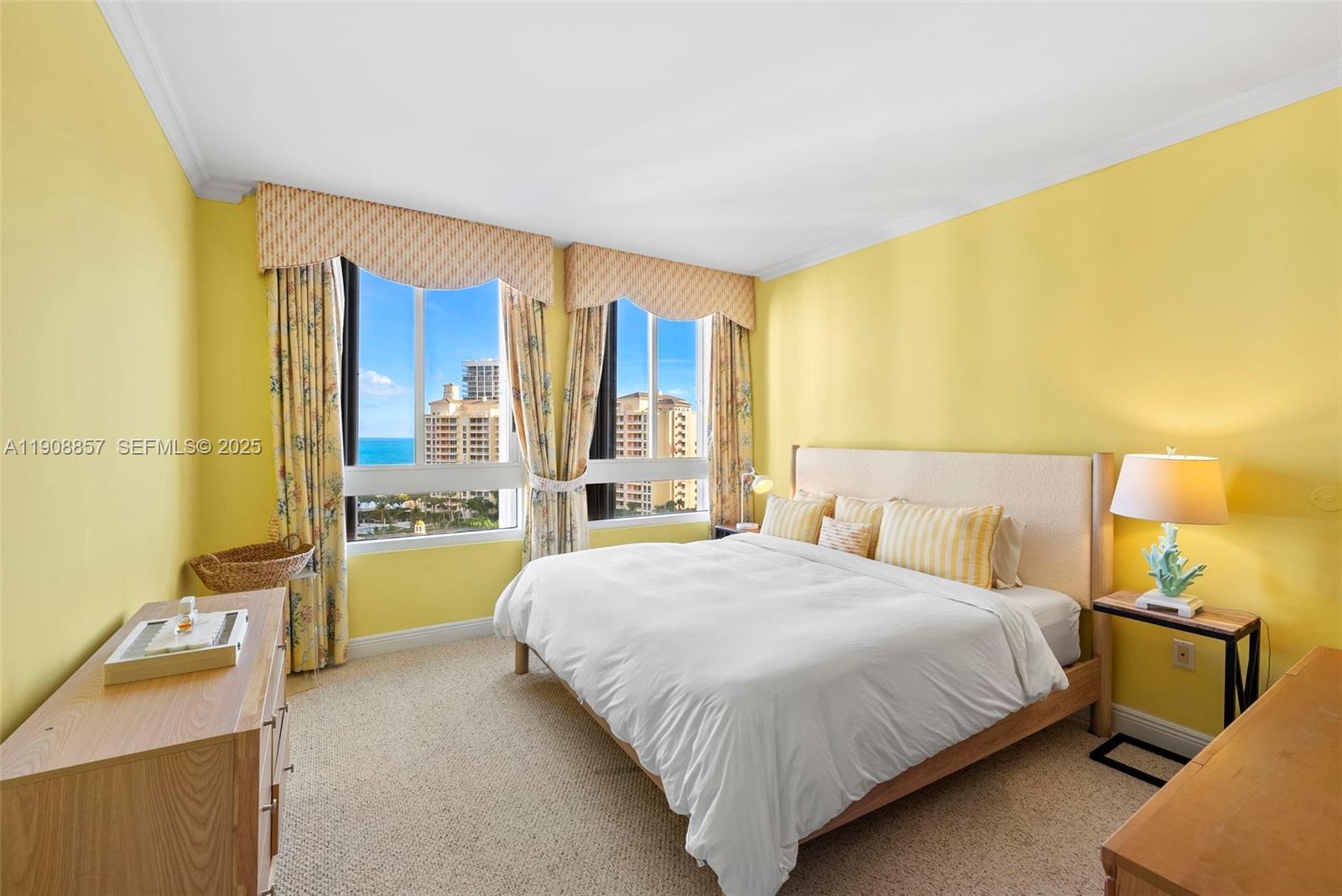 781 Crandon Boulevard, Unit 1406 Key Biscayne, FL 33149 - Photo 16 of 47 a bedroom with a bed and a dresser next to a blue wall