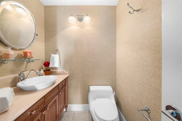 a bathroom with a sink vanity mirror and toilet