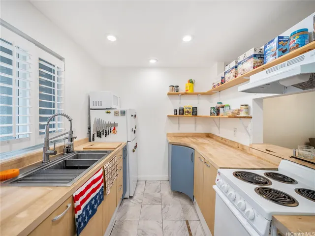 a kitchen with stainless steel appliances a sink a stove and a refrigerator