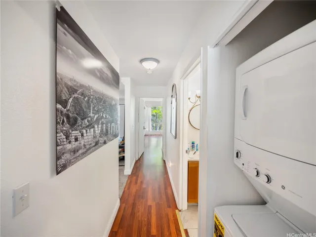 a view of a hallway with furniture and wooden floor