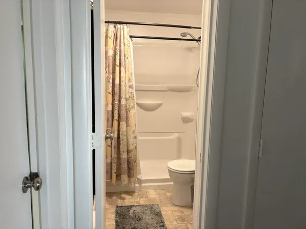 a bathroom with a granite countertop shower a toilet and a shower