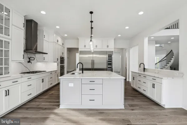 a large kitchen with stainless steel appliances granite countertop a stove oven and a white refrigerator