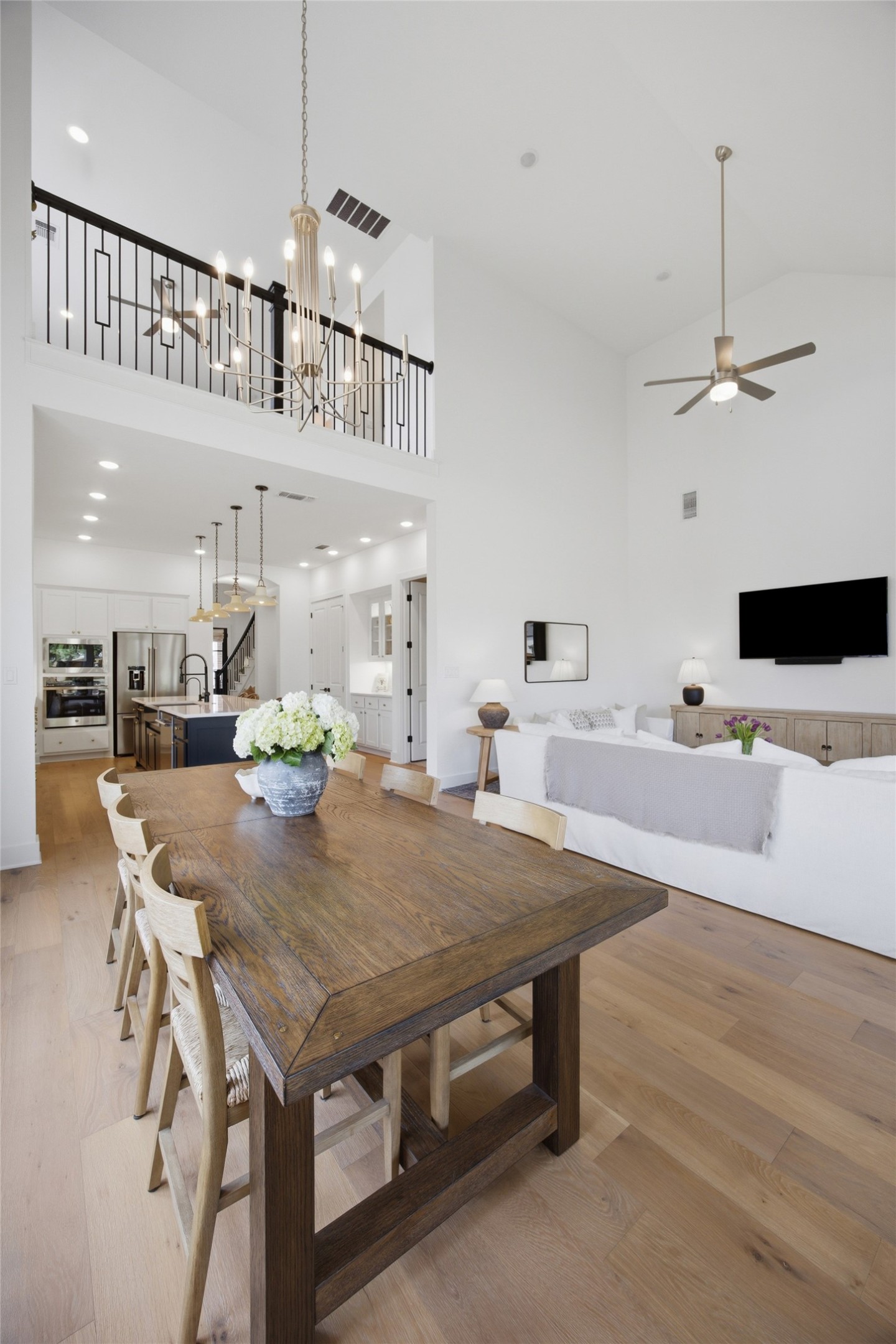 1217 Calendula Trail Georgetown, TX 78628 - Photo 17 of 39 Dining area featuring light wood-type flooring, a ceiling fan, a high ceiling, and hanging lights
