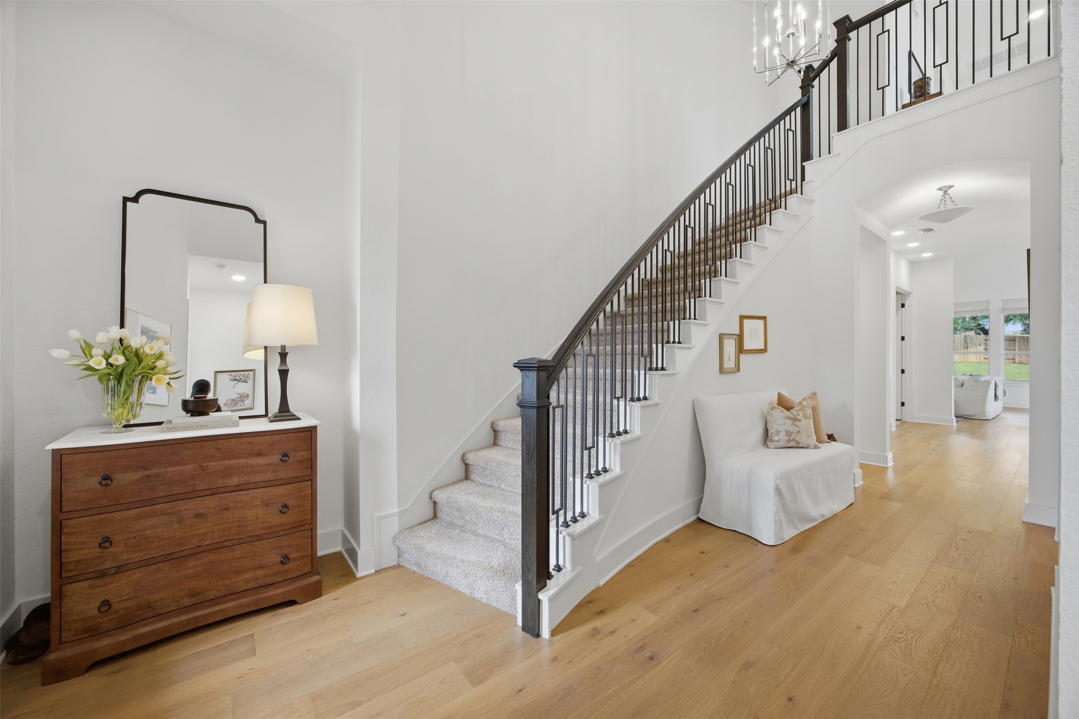 1217 Calendula Trail Georgetown, TX 78628 - Photo 26 of 39 Staircase featuring wood finished floors, a high ceiling, and a chandelier