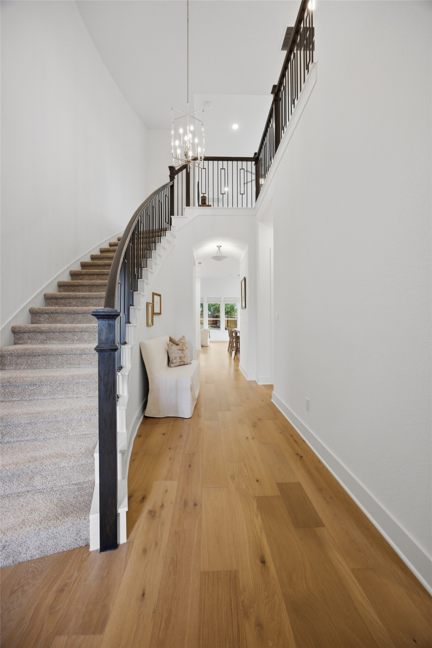 1217 Calendula Trail Georgetown, TX 78628 - Photo 4 of 39 Stairway with hardwood / wood-style flooring, a high ceiling, and suspended lighting