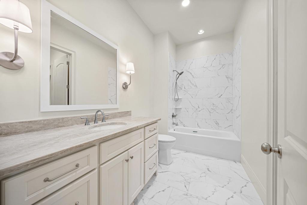 707 Vickery Street Extension Hartwell, GA 30643 - Photo 30 of 50 Marble-look tile and a clean white vanity create a fresh, inviting atmosphere in this well-appointed bathroom.