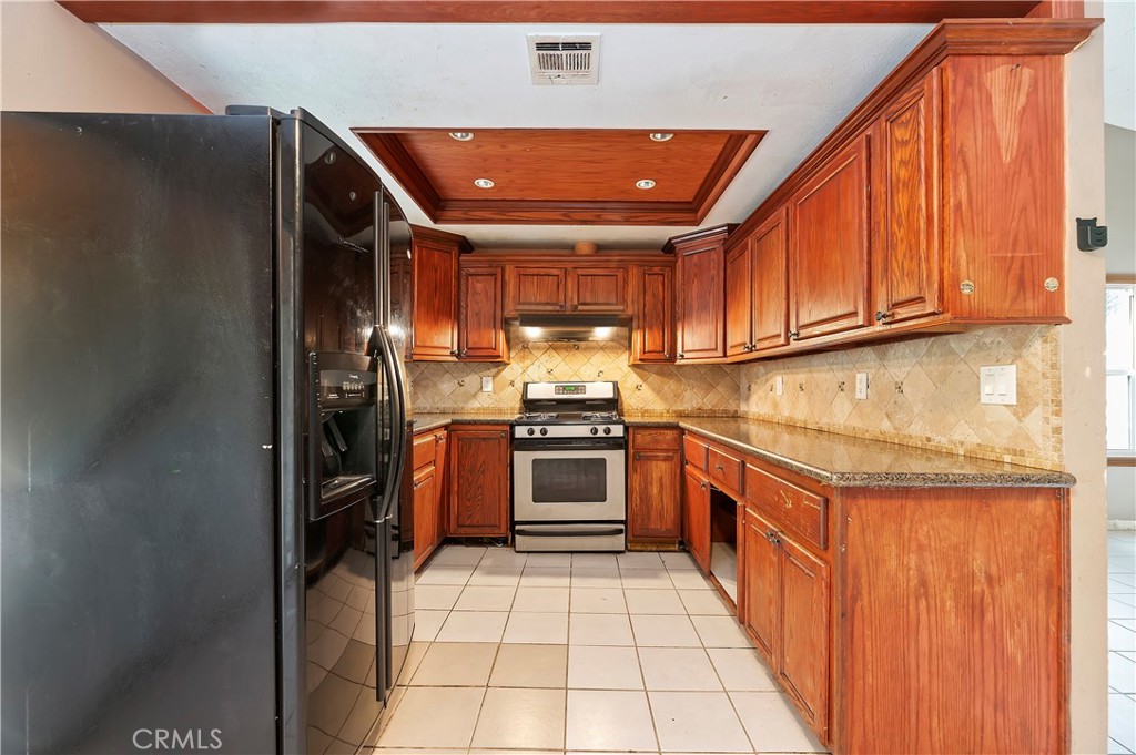 1959 Thornton Street Riverside, CA 92507 - Photo 13 of 26 a kitchen with stainless steel appliances granite countertop a stove top oven a sink and dishwasher