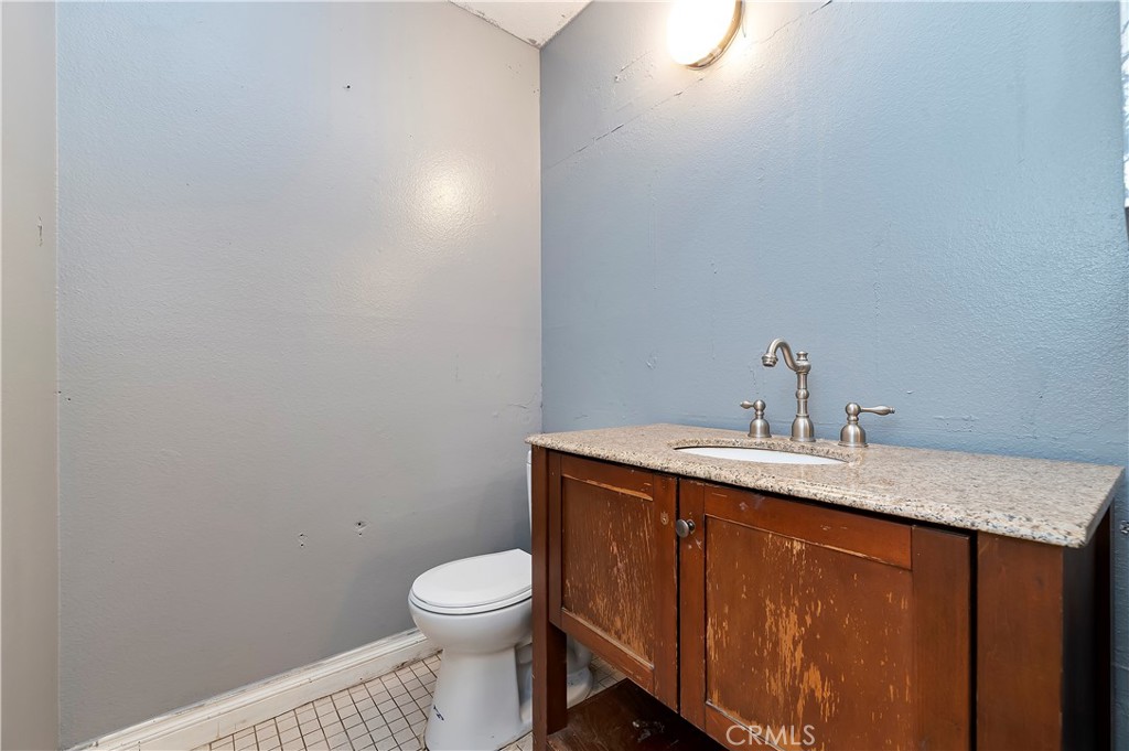 1959 Thornton Street Riverside, CA 92507 - Photo 17 of 26 a bathroom with a granite countertop sink a toilet and a mirror