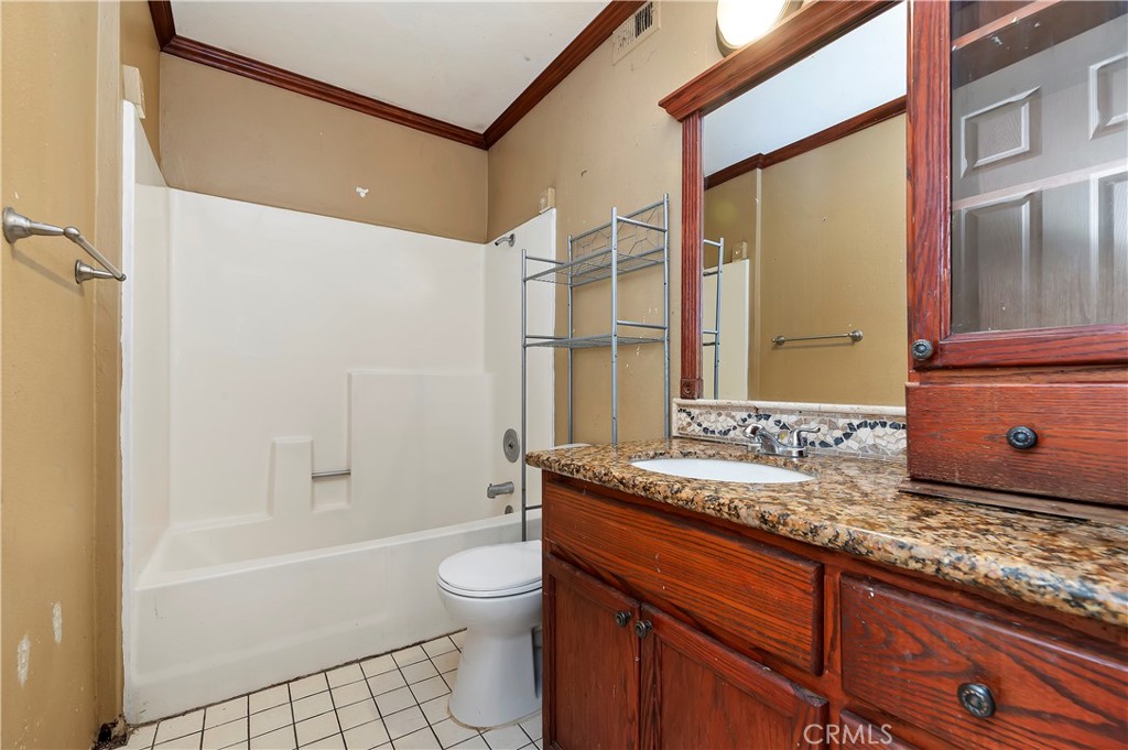 1959 Thornton Street Riverside, CA 92507 - Photo 20 of 26 a bathroom with a granite countertop sink a mirror and a bathtub