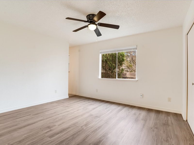 3908 Holt Drive Austin, TX 78749 - Photo 15 of 22 Room with light wood-like laminate floors, a textured ceiling, and a ceiling fan