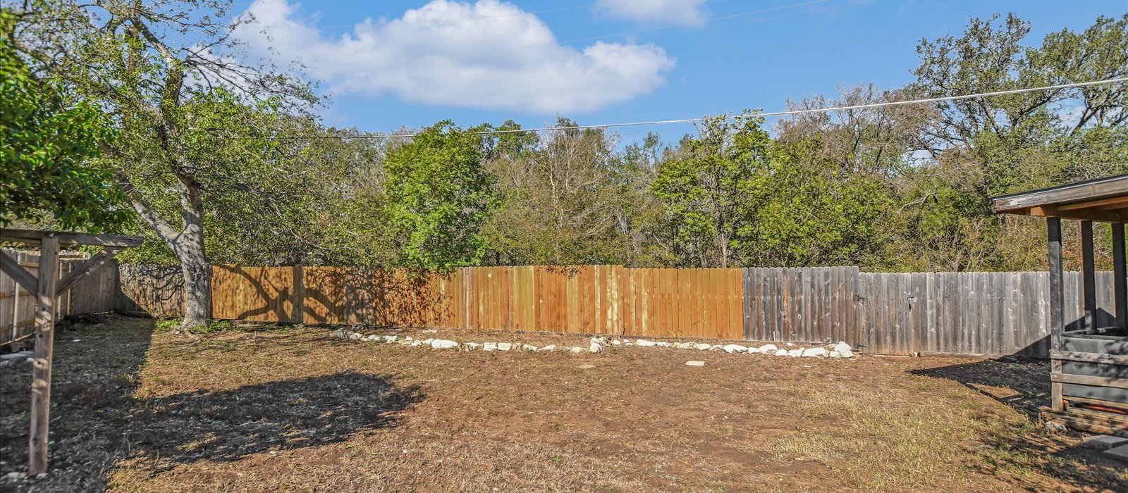 3908 Holt Drive Austin, TX 78749 - Photo 20 of 21 a view of a backyard with large trees and wooden fence