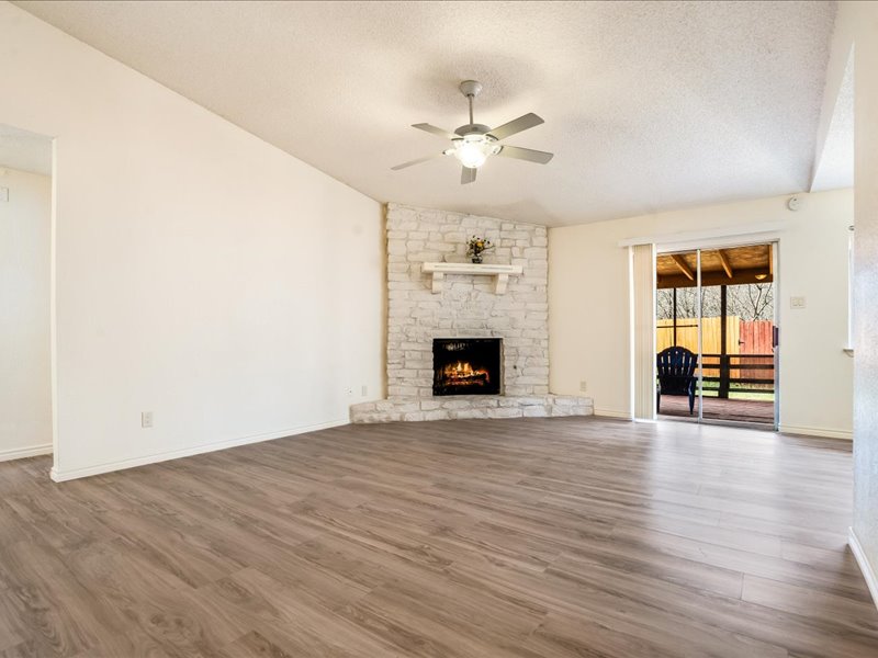 3908 Holt Drive Austin, TX 78749 - Photo 3 of 22 Spacious living room with a ceiling fan, natural light, wood finished floors, and a fireplace