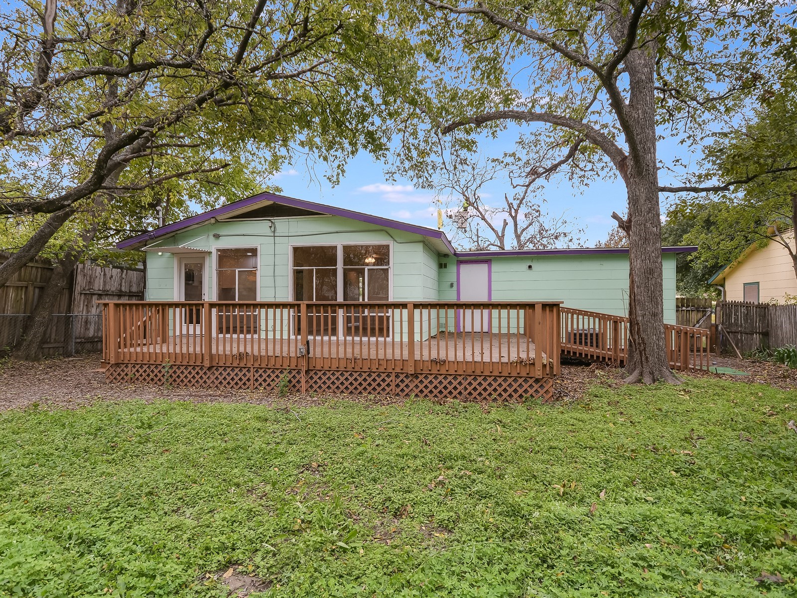 112 East Skyview Road Austin, TX 78752 - Photo 9 of 10 a white house that has a small yard and large trees
