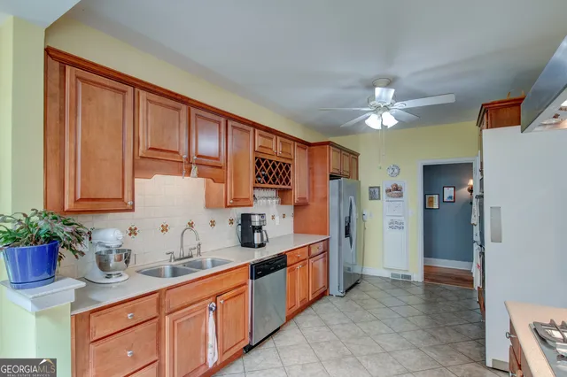 a kitchen with stainless steel appliances granite countertop a sink a stove and a refrigerator
