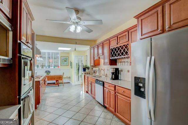 a large kitchen with stainless steel appliances granite countertop a refrigerator and a sink