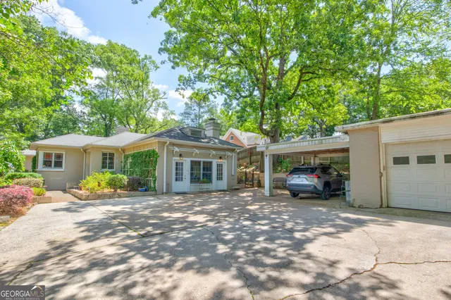 a front view of a house with a garden and trees