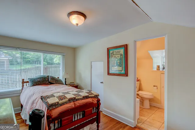 a bedroom with a bed and a lamp next to a window