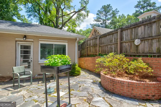 a view of a backyard with chair and potted plants