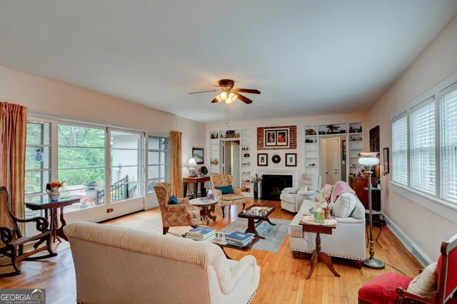 a living room with furniture fireplace and a large window