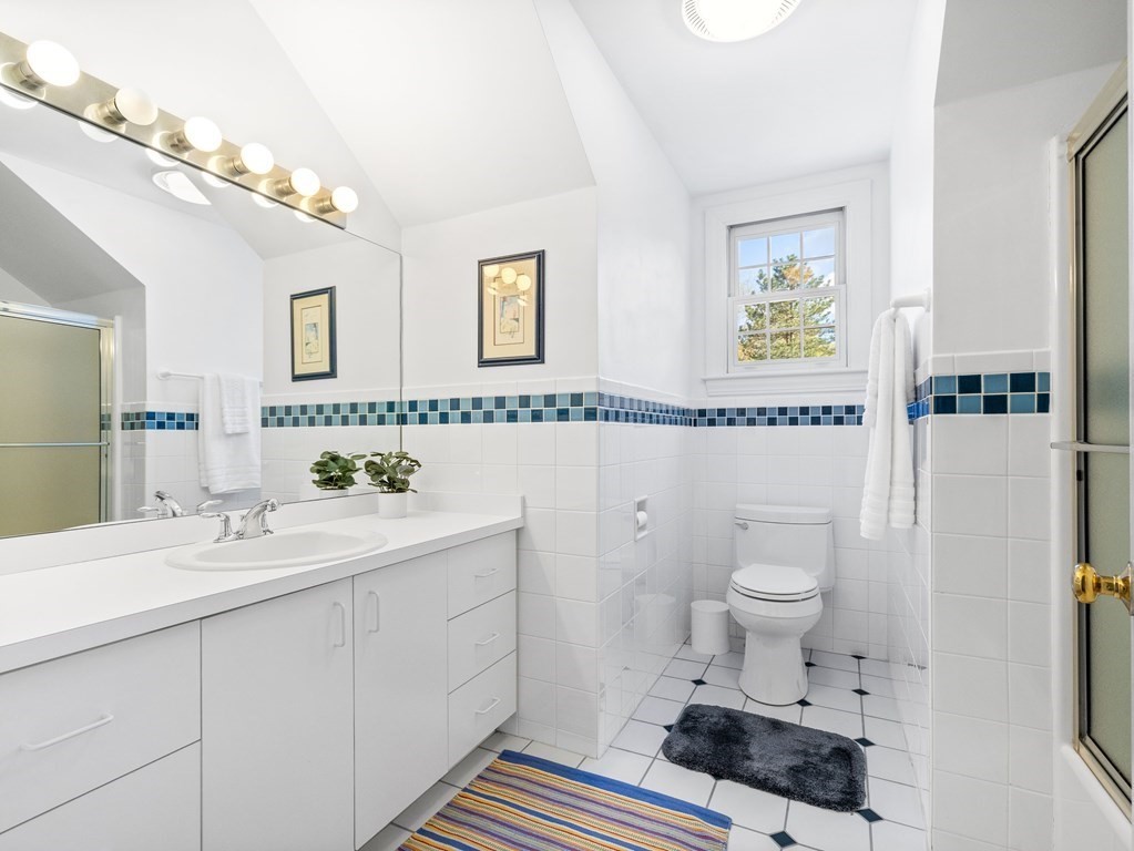 14 Moccasin Path Natick, MA 01760 - Photo 26 of 34 a bathroom with a sink toilet a mirror and vanity