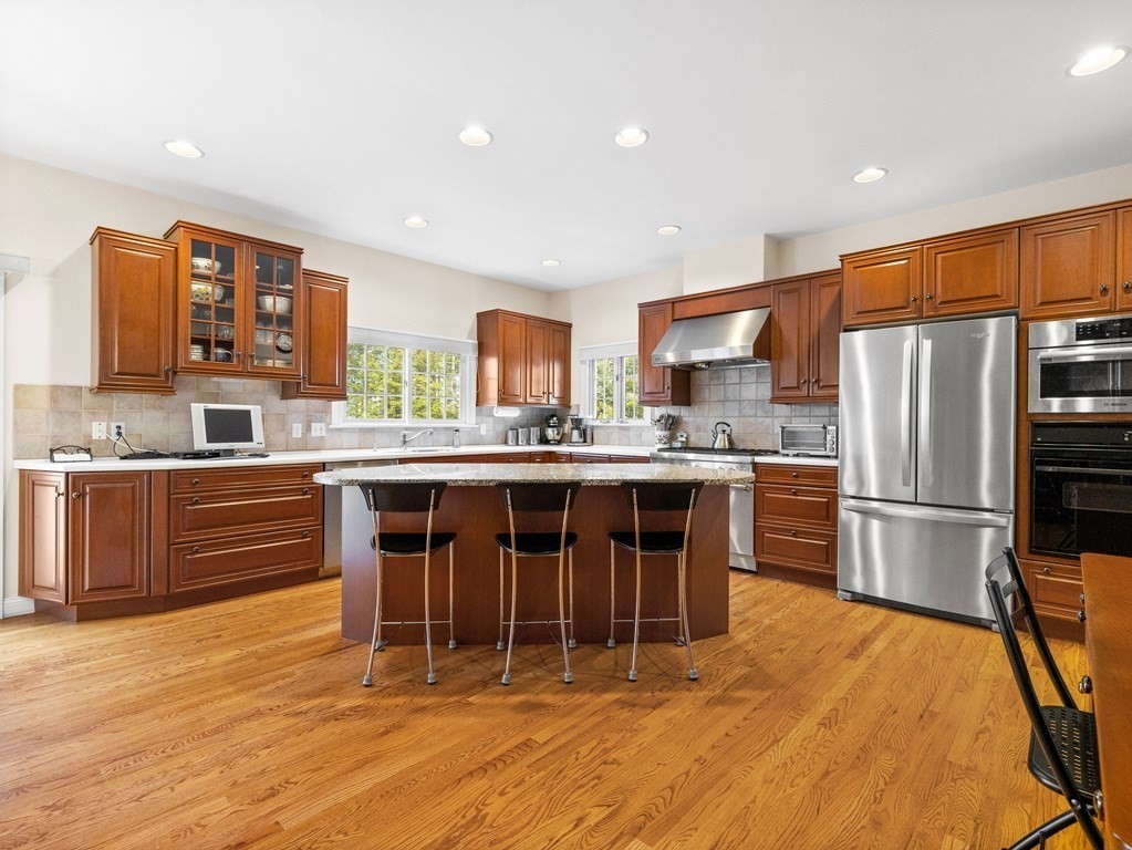 14 Moccasin Path Natick, MA 01760 - Photo 9 of 34 a kitchen with stainless steel appliances a refrigerator a stove a sink dishwasher with a dining table and chairs