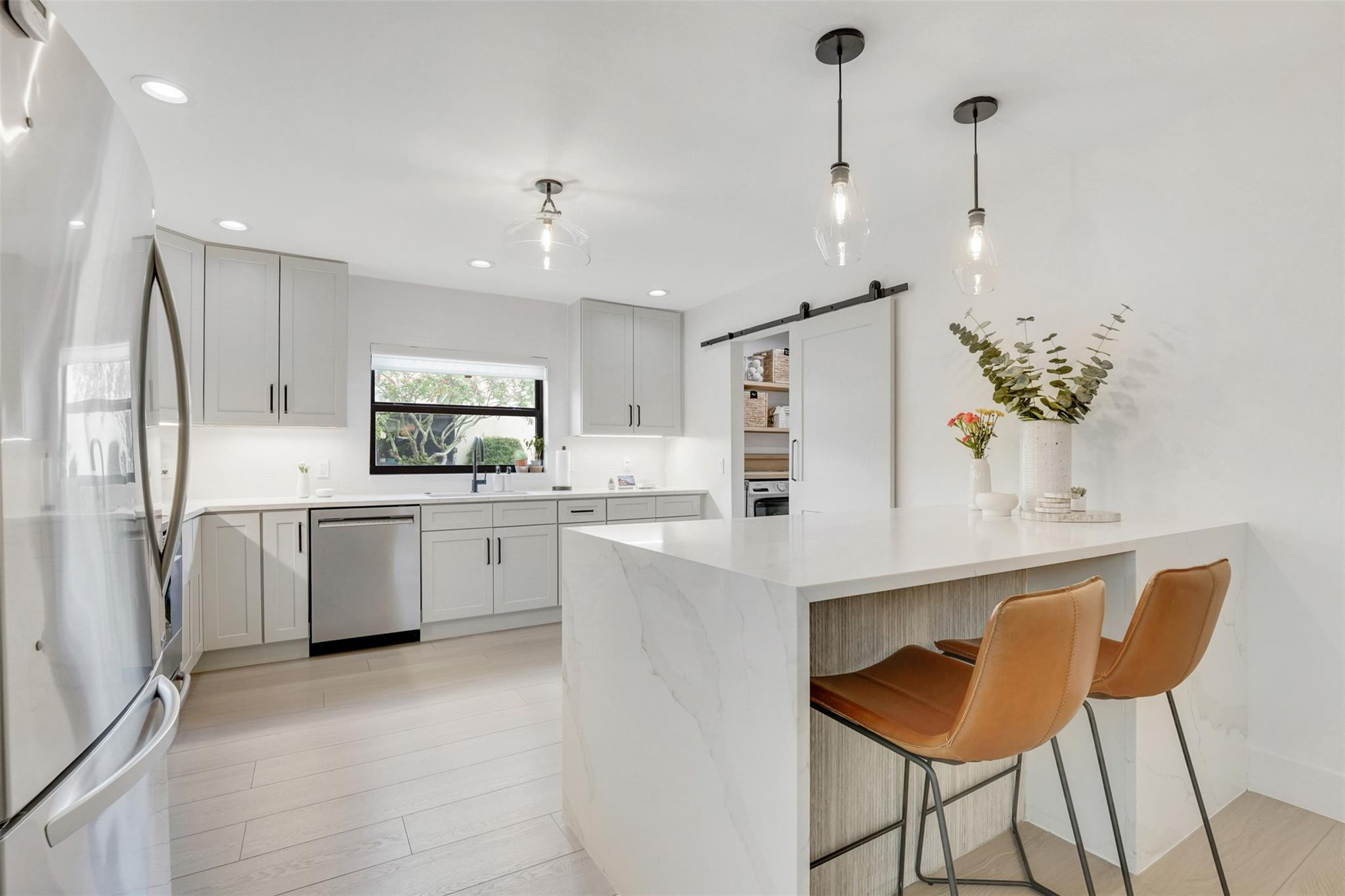 8569 Casa Del Lago Boca Raton, FL 33433 - Photo 5 of 25 a kitchen with white cabinets and stainless steel appliances