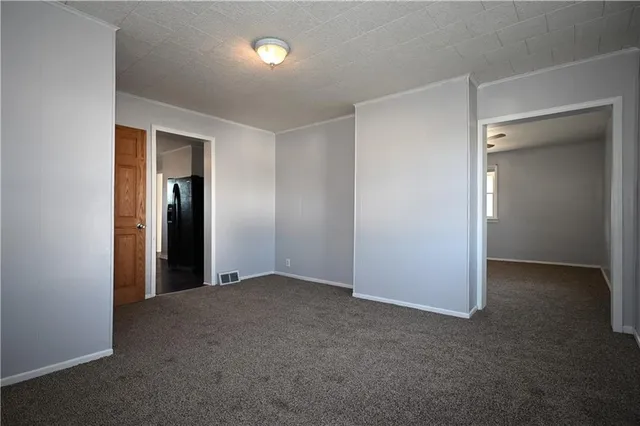 an empty room with closet and a hallway