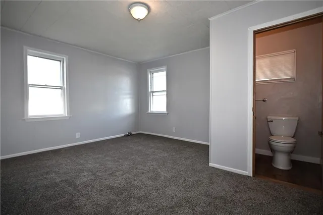 an empty room and a bathroom with toilet