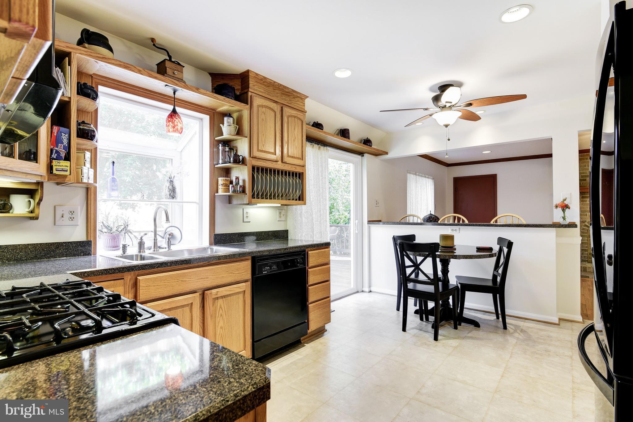 905 Pointer Ridge Drive Gaithersburg, MD 20878 - Photo 8 of 30 a kitchen with stainless steel appliances granite countertop a stove a sink dishwasher and a dining table with wooden floor