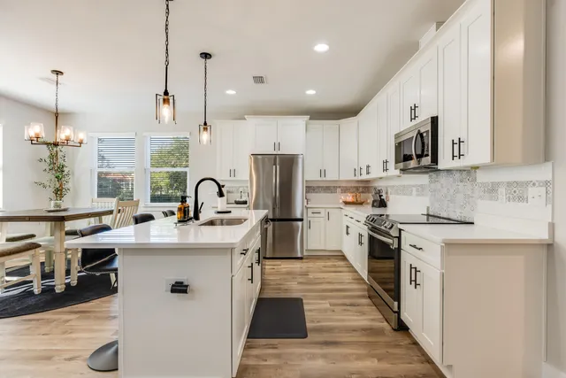 a kitchen with stainless steel appliances granite countertop a sink stove and refrigerator