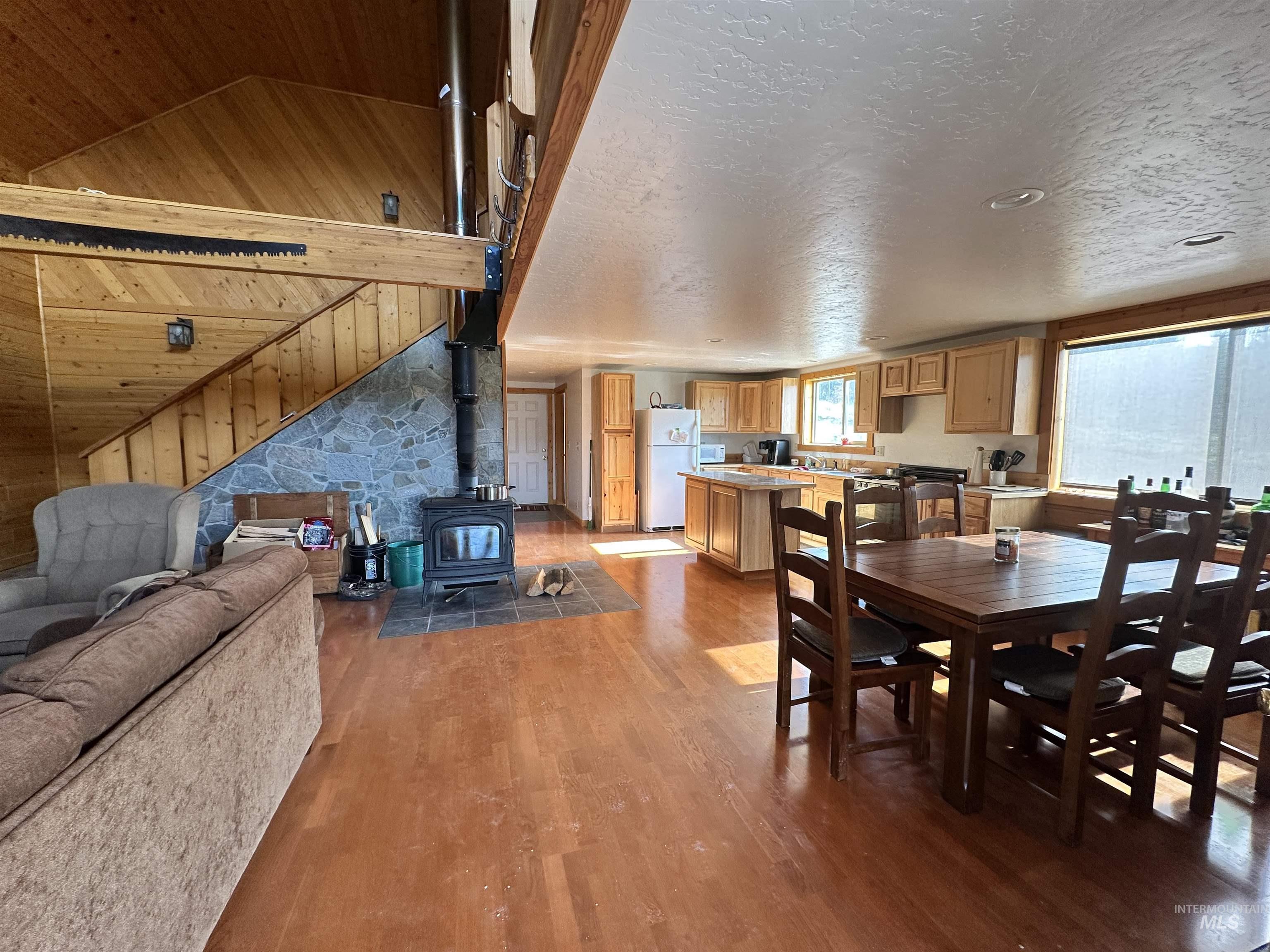 532 Warren Creek Road McCall, ID 83638 - Photo 6 of 45 Dining room featuring lofted ceiling, a wood stove, wood finished floors, and wood walls
