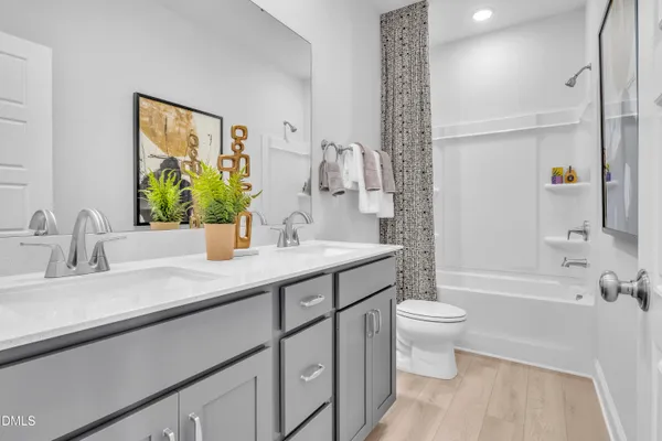 a bathroom with a double vanity sink toilet and shower