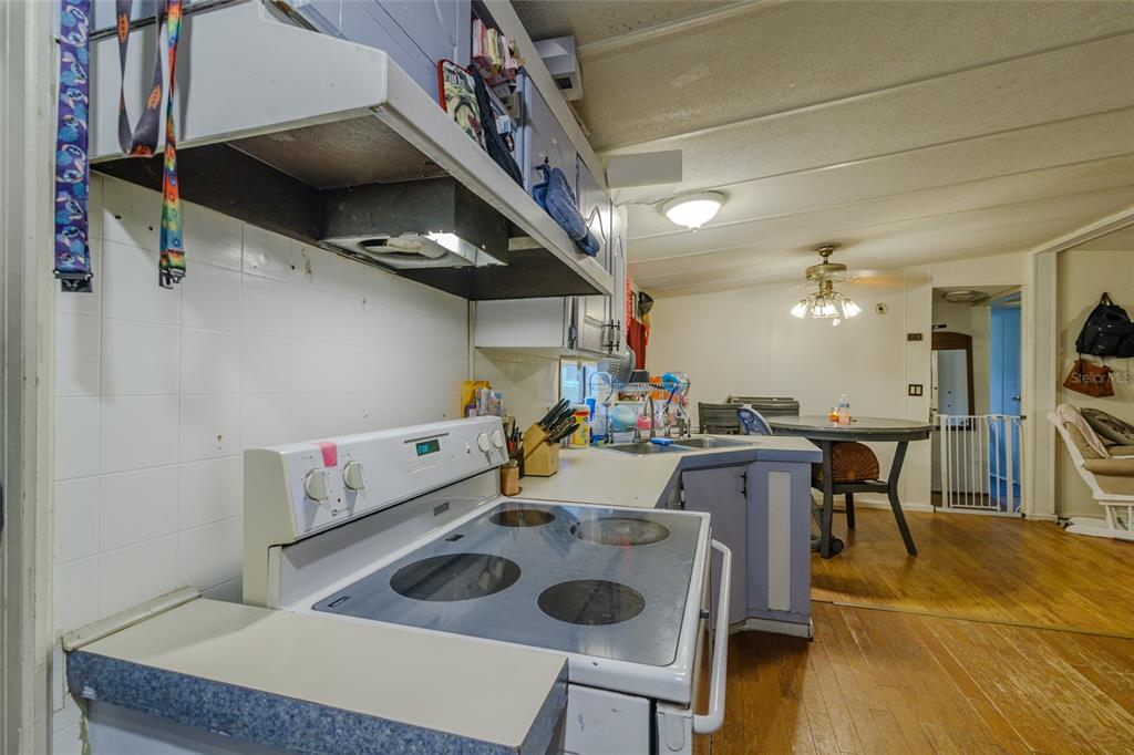 4225 Southwest 178th Terrace Dunnellon, FL 34432 - Photo 26 of 49 a kitchen with a stove a refrigerator and a dining table with wooden floor