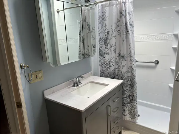 a bathroom with a sink a mirror and shower