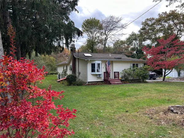 a front view of a house with a garden and trees
