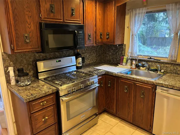 a kitchen with stainless steel appliances granite countertop a stove microwave and cabinets