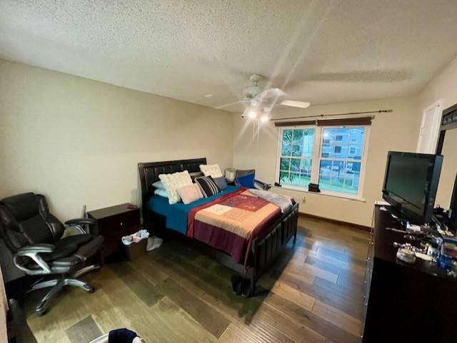 4245 Madera Road Irving, TX 75038 - Photo 8 of 10 Bedroom with a textured ceiling, dark wood-style flooring, a desk, and a ceiling fan