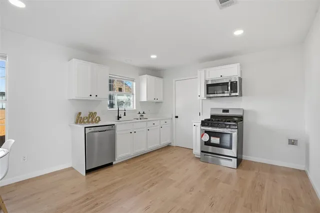 a kitchen with stainless steel appliances a stove a sink and a microwave