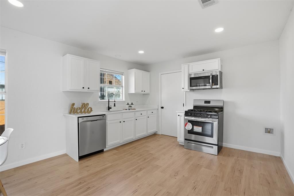 2012 Tennessee Avenue Dallas, TX 75224 - Photo 10 of 28 a kitchen with stainless steel appliances a stove a sink and a microwave