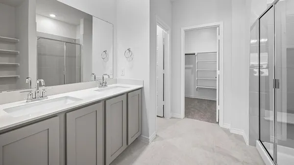 a bathroom with a double vanity sink mirror and shower