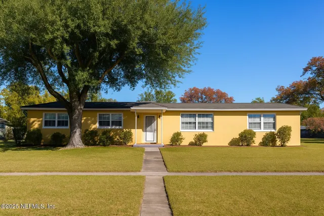 a front view of house with yard and trees around