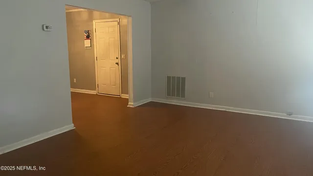 an empty room with windows and closet